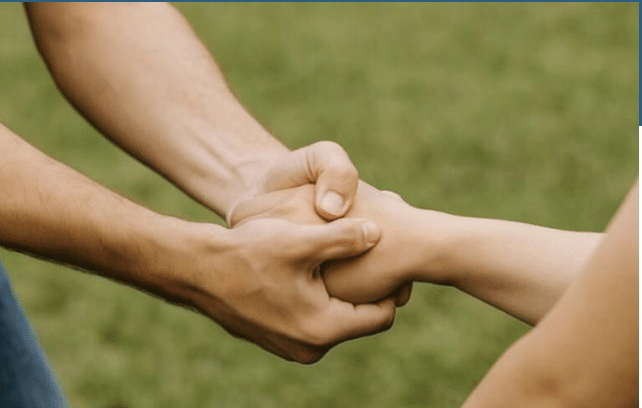 Person holding another person's hand with both hands
